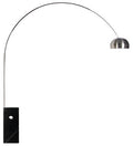 Una vista interior de un moderno y elegante comedor con una imponente lámpara de pie arqueada NEW ARC BIG. La estructura de cromo brillante de la lámpara forma un gran arco sobre la mesa del comedor, con una pantalla esférica.