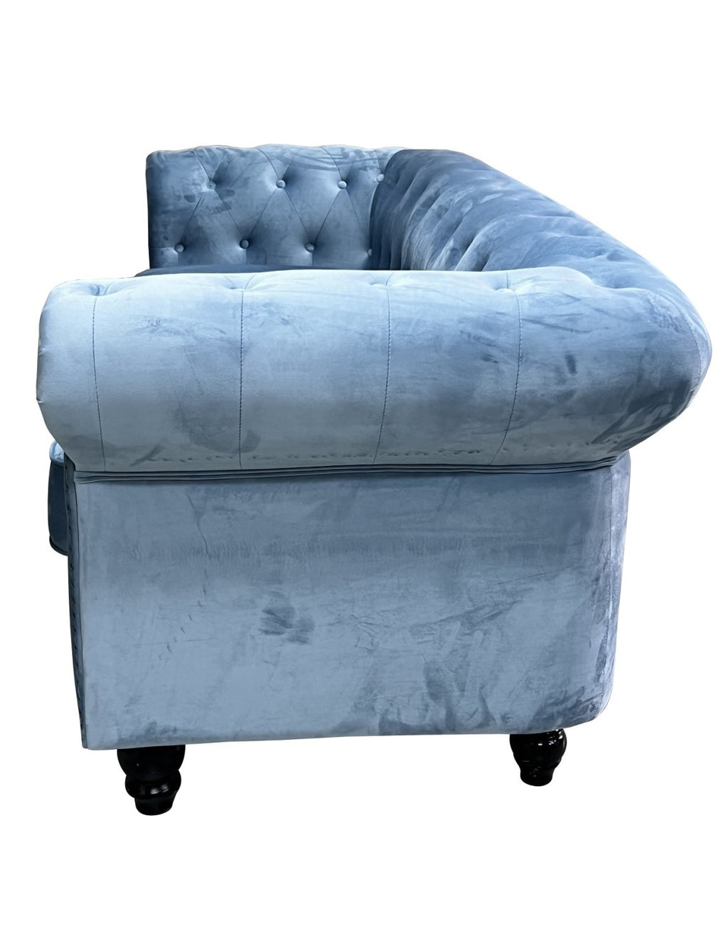 Sofá de dos plazas tapizado en terciopelo azul dusky apagado, perfil bajo, cojines integrados y patas oscuras.