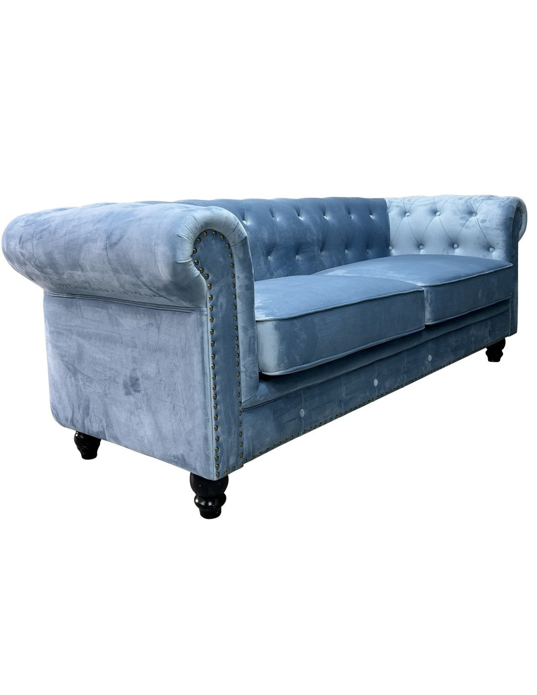 Sofá de tres plazas tapizado en terciopelo azul dusky apagado, perfil bajo, cojines integrados y patas oscuras. 