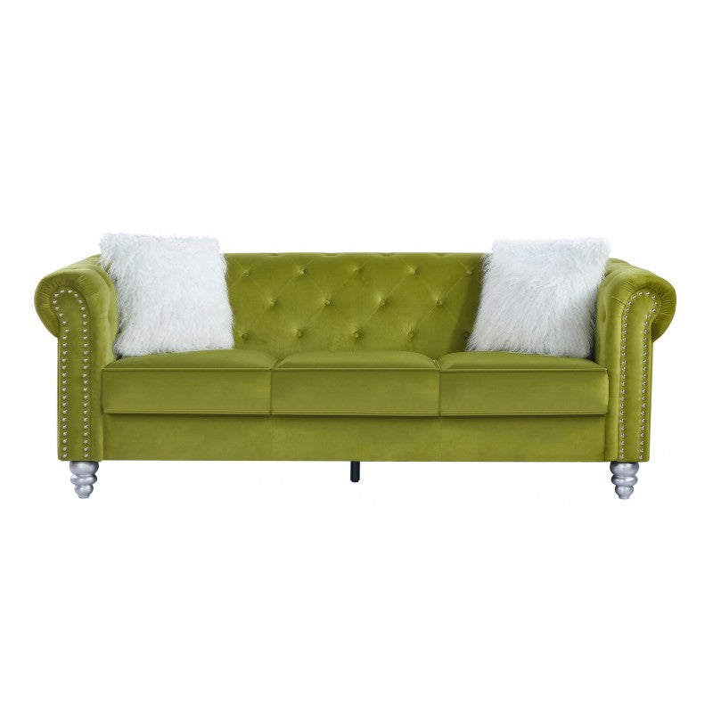 Elegante sofá de tres plazas en tejido velvet verde oscuro presidiendo un salón moderno y luminoso, aportando un toque de lujo sofisticado y confort mediterráneo.
