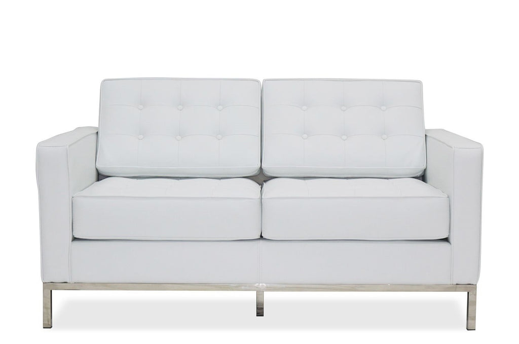 Sofá de dos plazas tapizado en similpiel blanca de acabado liso y luminoso, con base de acero inoxidable en acabado brillo y dos cojines de asiento integrados. 